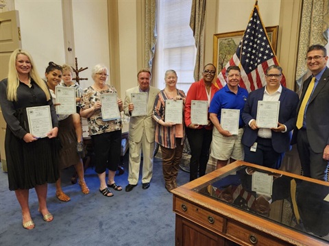 photo of people who helped HB 147 become a reality holding copies of signed Bill in Governors office